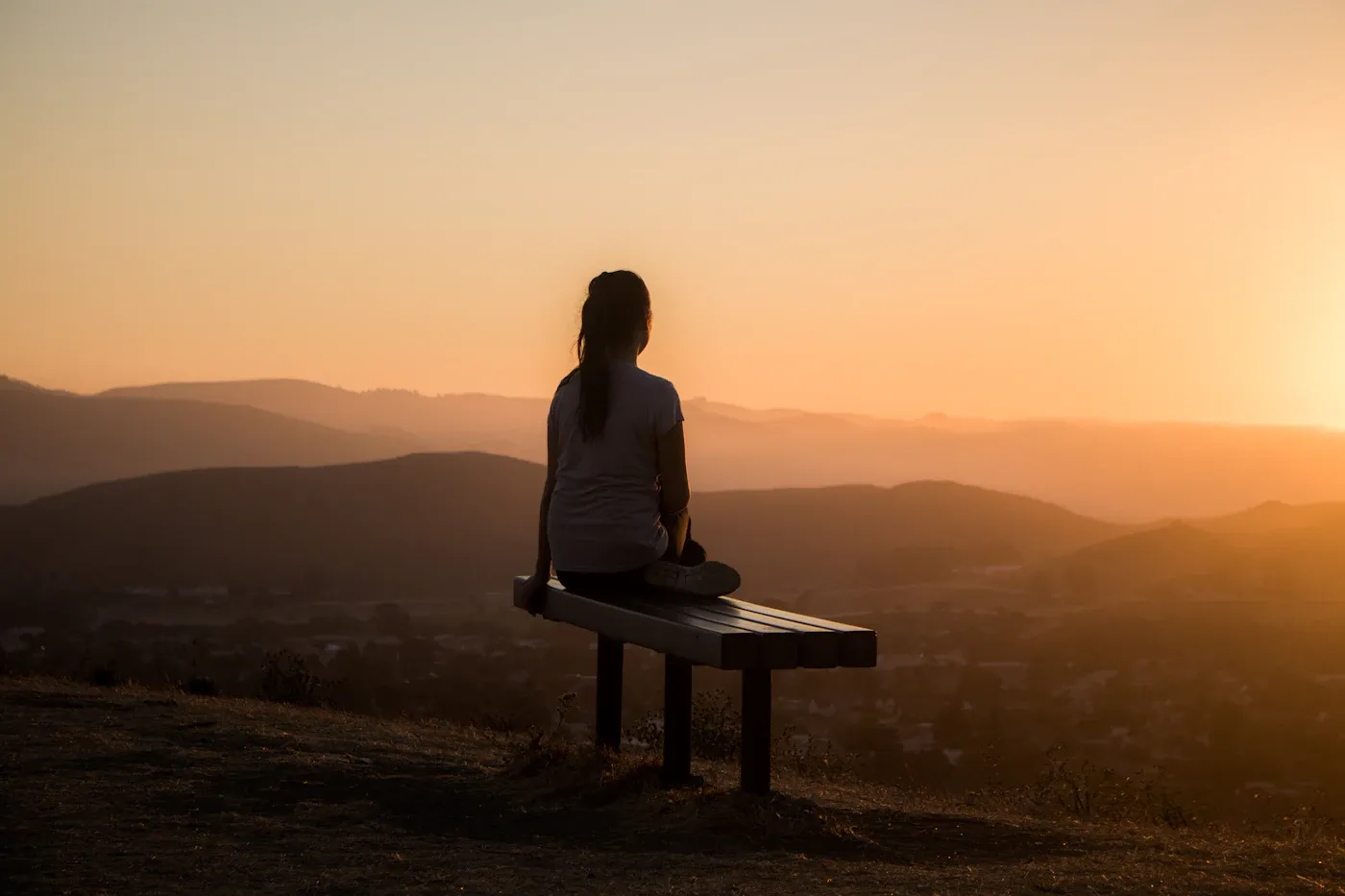 How to Regulate Emotions When Everything Feels Like Too Much Person sitting calmly at sunset, learning how to regulate emotions
