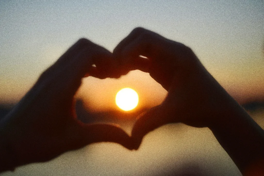 Self-Compassion: How to Talk Back to Your Inner Critic Hands shaped like a heart against the sunset, a symbol of self-compassion