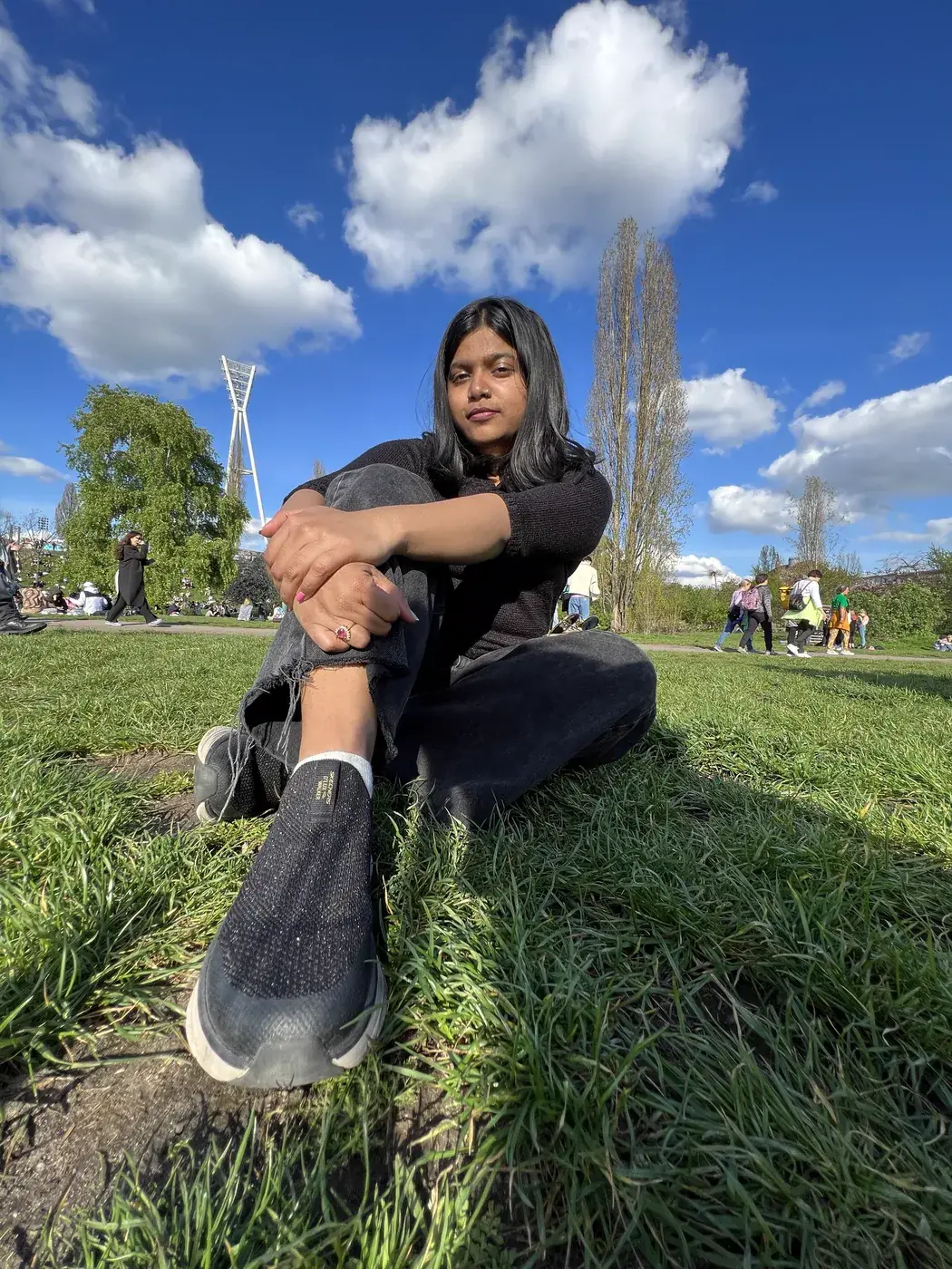 Meet Gayatri Gayatri sitting on the grass in a park on a sunny day